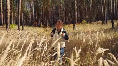 4K调调镜头，年轻女子带着背包徒步穿越森林，穿过高大的草地